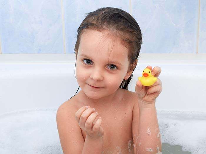 Cute baby bathing in a bath tub using foamo